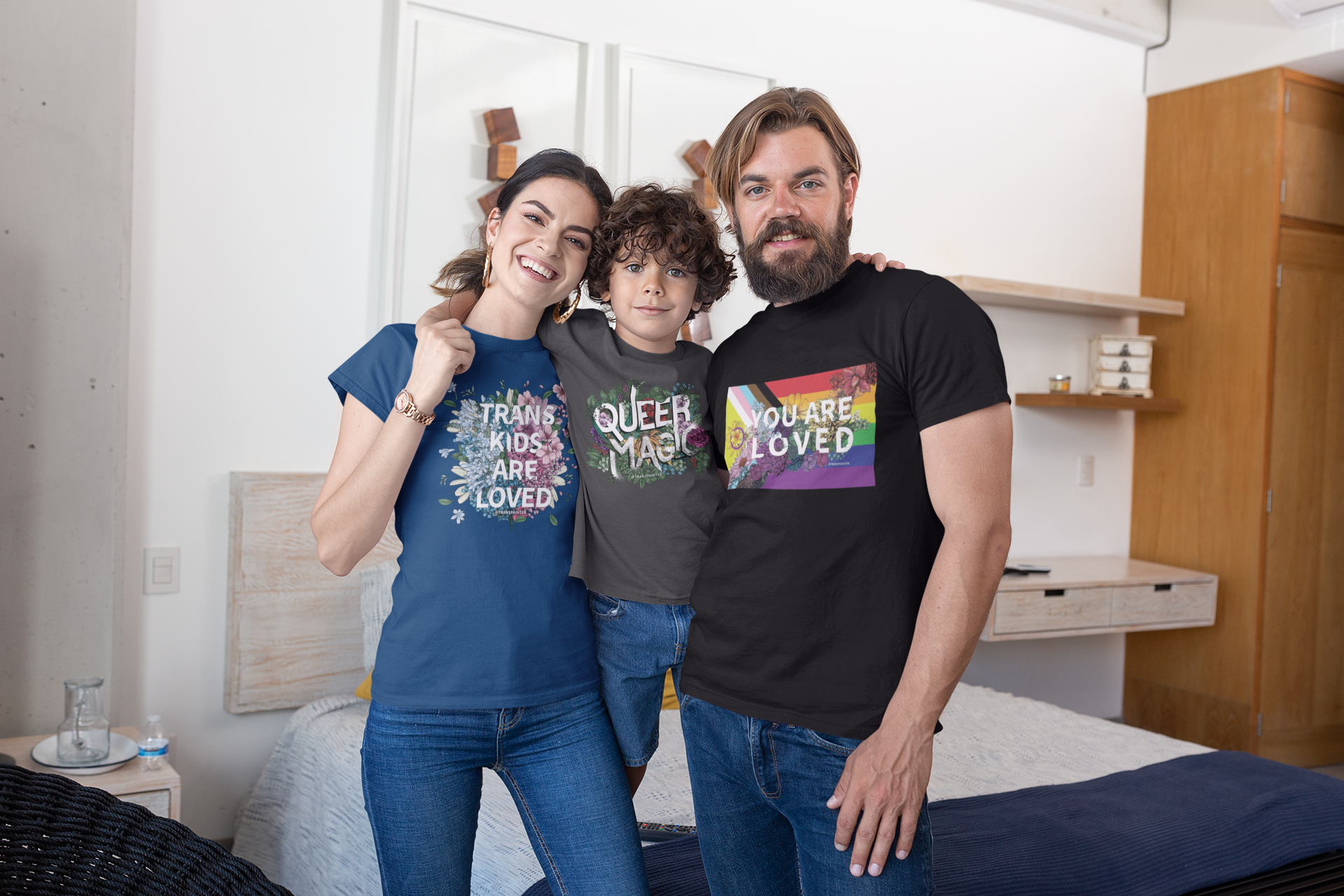 An LGBT Family wears LBTQ+ Pride t-shirts and smiles at home